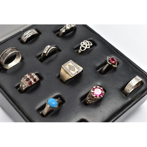 33 - A SELECTION OF SILVER AND MAINLY WHITE METAL RINGS, sitting on a ring pad comprising twelve rings, t... 