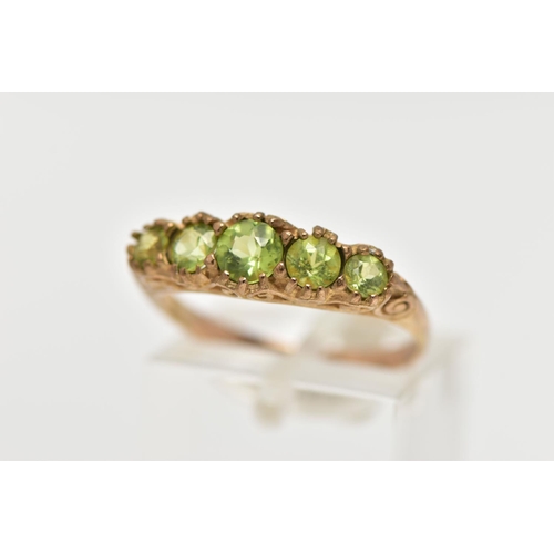 40 - A 9CT GOLD FIVE STONE PERIDOT RING, designed with five graduated circular cut peridots, scrolling ga... 