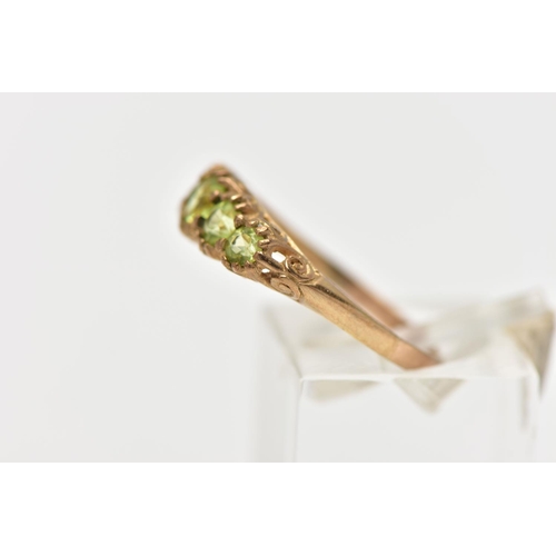 40 - A 9CT GOLD FIVE STONE PERIDOT RING, designed with five graduated circular cut peridots, scrolling ga... 