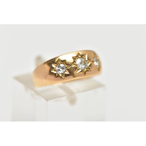 52 - AN 18CT GOLD DIAMOND THREE STONE RING, the graduated old cut diamonds, within a star setting, to the... 