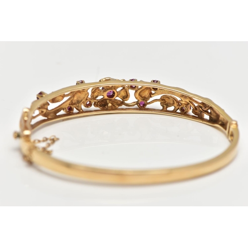 59 - A 9CT GOLD FLORAL BANGLE, a yellow gold oval form hinged bangle, open work textured detail set with ... 