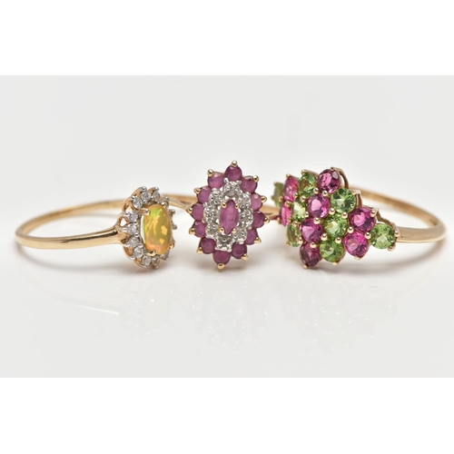 6 - THREE GEM SET RINGS, the first designed as a tiered lozenge shape cluster centring on a marquise cut... 