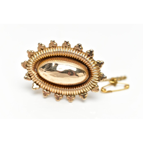 63 - AN EARLY 20TH CENTURY GOLD ETRUSCAN BROOCH, a yellow gold brooch of oval form, domed centre with tex... 