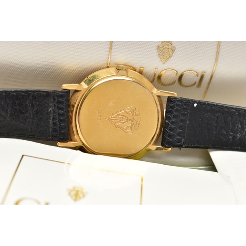 67 - A 'GUCCI' QUARTZ WRISTWATCH, round black dial signed 'Gucci, Swiss Made', gold tone hands, Roman num... 