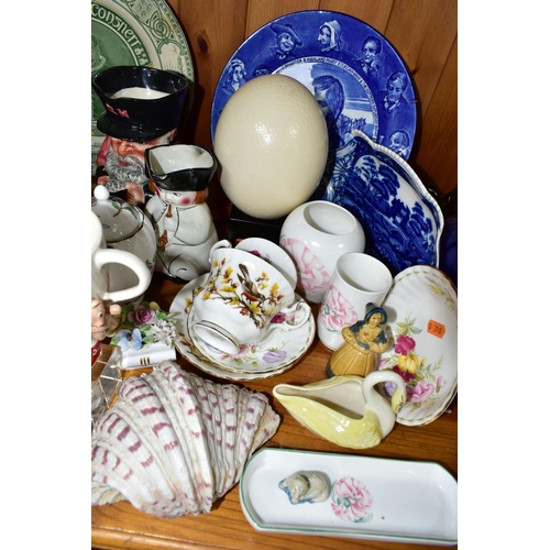 332 - A GROUP OF CERAMIC ORNAMENTS comprising an ostrich egg on a square wooden stand, a Royal Doulton 191... 