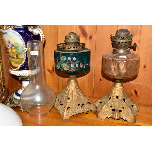 393 - A GROUP OF VICTORIAN OIL LAMPS comprising two cast iron lamp bases with brass Duplex fittings one ha... 