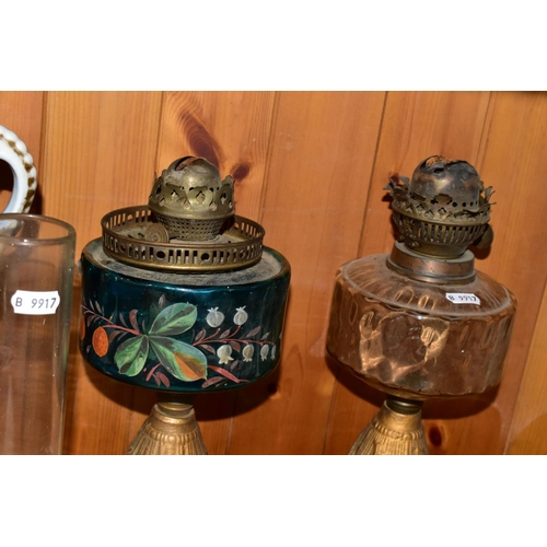 393 - A GROUP OF VICTORIAN OIL LAMPS comprising two cast iron lamp bases with brass Duplex fittings one ha... 