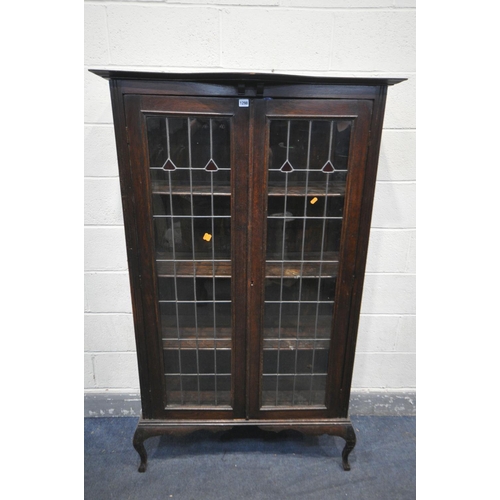 1199 - AN EARLY 20TH CENTURY ARTS AND CRAFTS TWO DOOR LEAD GLAZED BOOKCASE, with a shaped top, on cabriole ... 