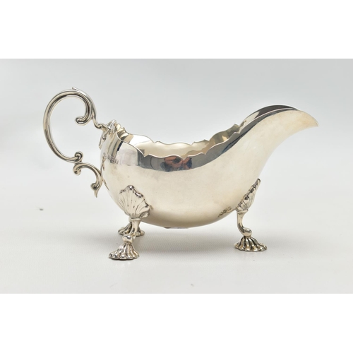 1055A - A GEORGE V SILVER SAUCEBOAT, wavy rim, 'C' scroll handle, on three cabriole legs with shell knees an... 