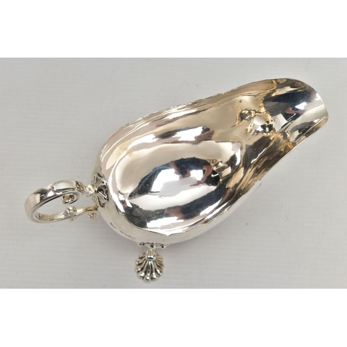 1055A - A GEORGE V SILVER SAUCEBOAT, wavy rim, 'C' scroll handle, on three cabriole legs with shell knees an... 