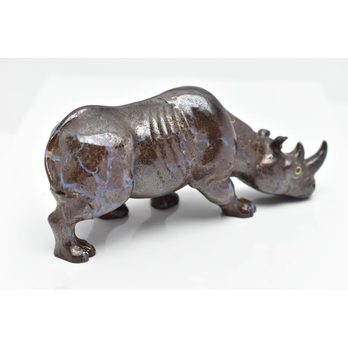 22 - A CARVED BOULDER OPAL RHINO, the figure designed as a rhino, carved from boulder opal, with green ga... 