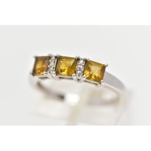 32 - A 9CT WHITE GOLD GEM SET RING, designed with a row of three square yellowish/green stones assessed a... 