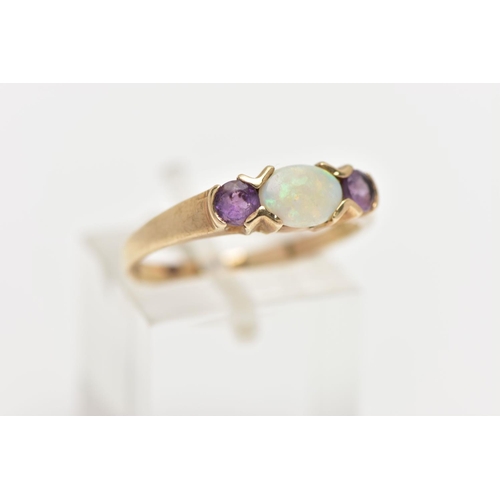 37 - A 9CT OPAL AND CUBIC ZIRCONIA RING, centring on an oval cut opal, tension set, flanked with circular... 