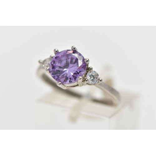 39 - A WHITE METAL CUBIC ZIRCONIA RING, set with a circular cut purple cubic zirconia in a six claw setti... 