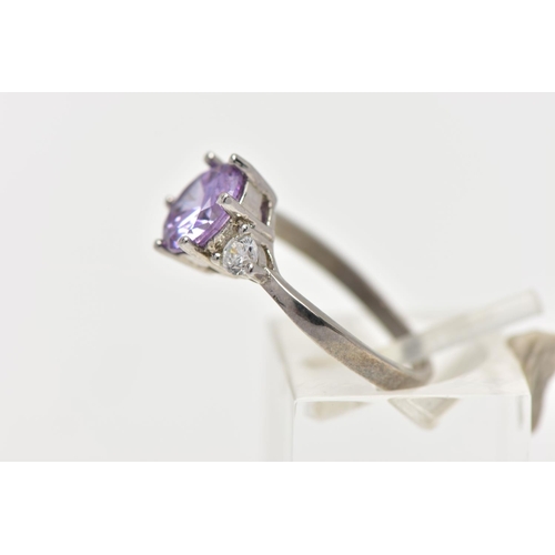 39 - A WHITE METAL CUBIC ZIRCONIA RING, set with a circular cut purple cubic zirconia in a six claw setti... 