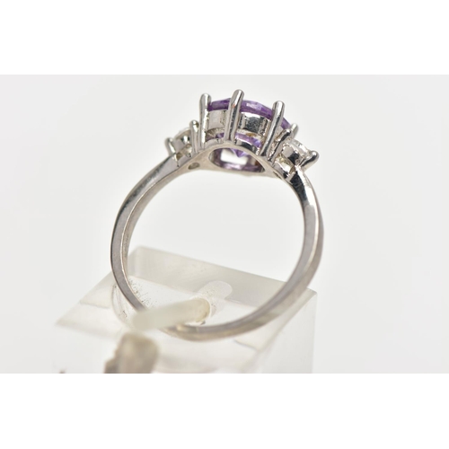 39 - A WHITE METAL CUBIC ZIRCONIA RING, set with a circular cut purple cubic zirconia in a six claw setti... 