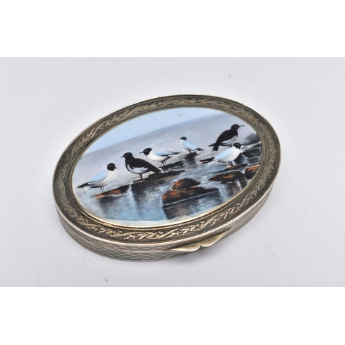 69 - A WHITE METAL HINGED TRINKET BOX, of an oval form, depicting seagulls on rocks to the cover, engine ... 