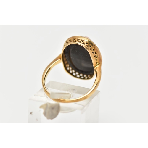 7 - A YELLOW METAL CAMEO RING, oval onyx panel set with a raised cameo of a lady in profile, milgrain co... 