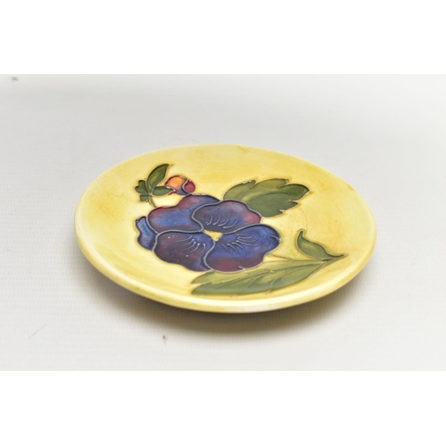 965A - A MOORCROFT POTTERY COASTER DECORATED WITH A PANSY ON A PALE YELLOW GROUND, impressed marks, bears b... 