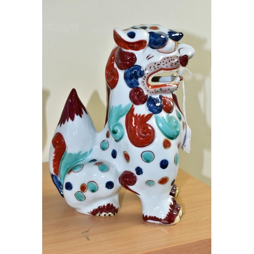 301 - AN ORIENTAL STYLE DOG OF FO CERAMIC FIGURE, in seated position, decorated with red, green and blue s... 