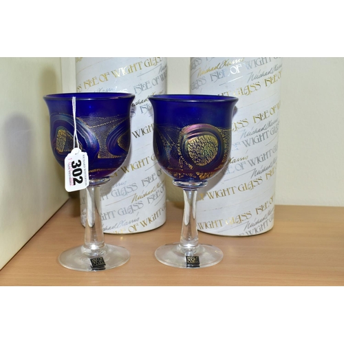 302 - TWO BOXED ISLE OF WIGHT WINE GLASSES, each bowl in blue glass with a gold band and iridescent looped... 