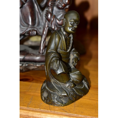 321 - FOUR ORIENTAL FIGURES, to include a hollow cast brass figure of a seated man with a book, height 12c... 