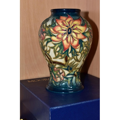 445 - A BOXED MOORCROFT POTTERY 'SPIKE' BALUSTER VASE, having tube lined orange and yellow flowers with sp... 