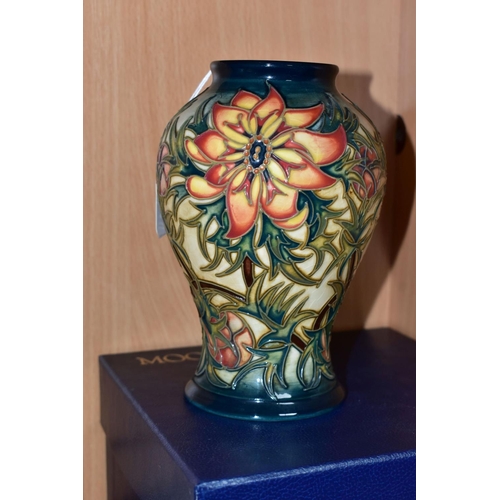 445 - A BOXED MOORCROFT POTTERY 'SPIKE' BALUSTER VASE, having tube lined orange and yellow flowers with sp... 