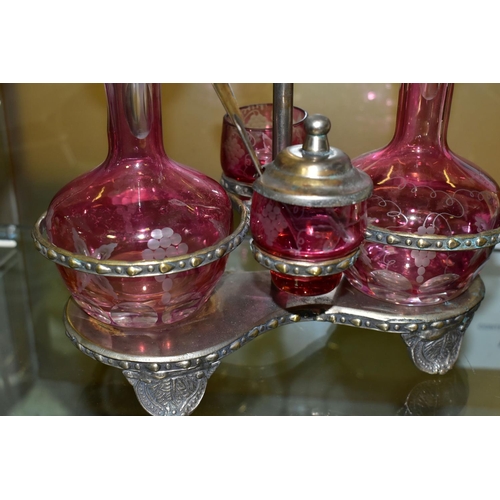 536 - A PINK STAINED GLASS AND PLATED CRUET, the stand fitted with two bottles and two preserve pots, cut ... 