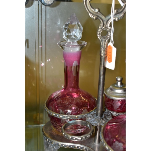 536 - A PINK STAINED GLASS AND PLATED CRUET, the stand fitted with two bottles and two preserve pots, cut ... 