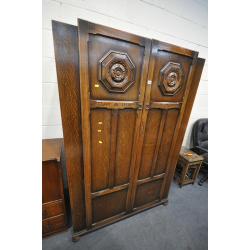 1203 - A 20TH CENTURY OAK TWO DOOR WARDROBE, the doors with a floral plaque, on bun feet, width 122cm x dep... 