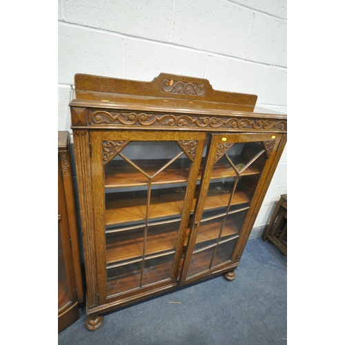 1205 - A 20TH CENTURY OAK SIDE BY SIDE BUREAU BOOKCASE, two glazed doors flanking a fall front door, above ... 