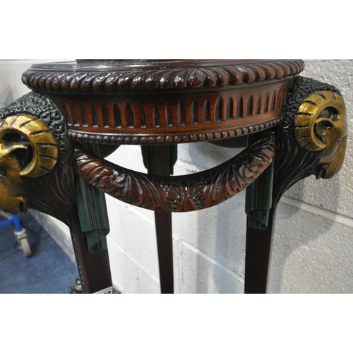 1243 - A MAHOGANY TORCHERE STAND, with three painted rams heads and central finial, on hoof style feet, dia... 