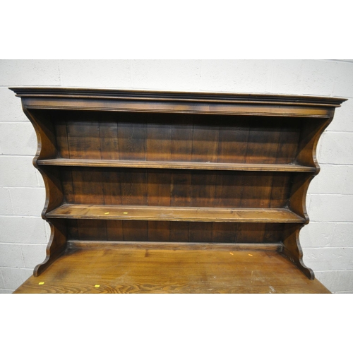 1244 - A 20TH CENTURY ELM DRESSER, the top with a two tier plate rack, base with three drawers over three c... 