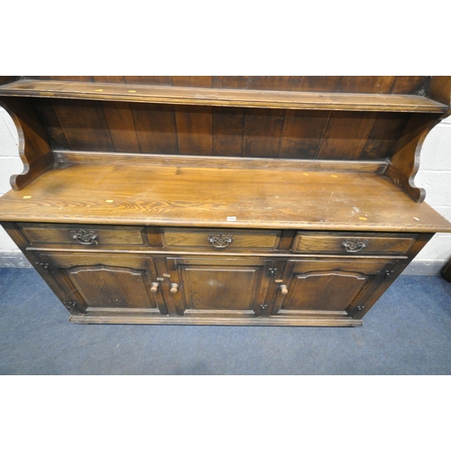 1244 - A 20TH CENTURY ELM DRESSER, the top with a two tier plate rack, base with three drawers over three c... 