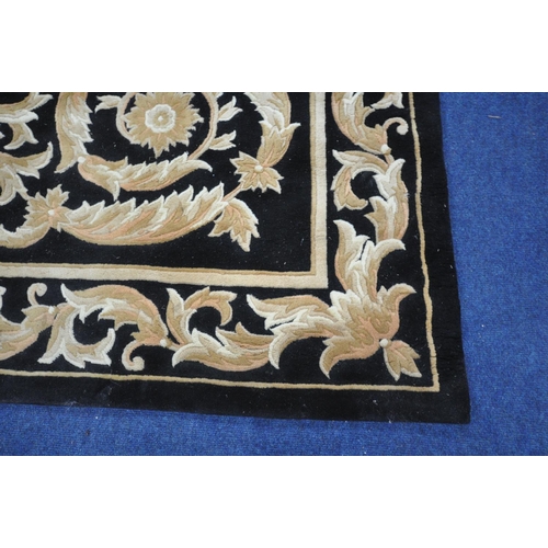 1283 - A G.H.FRITH CHINESE HANDKNOTTED BLACK GROUND RUG  with brown and beige foliate detailing and a centr... 