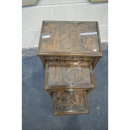 1286 - AN ORIENTAL NEST OF THREE TABLES with recessed carved scenes to top and freize together with two ori... 