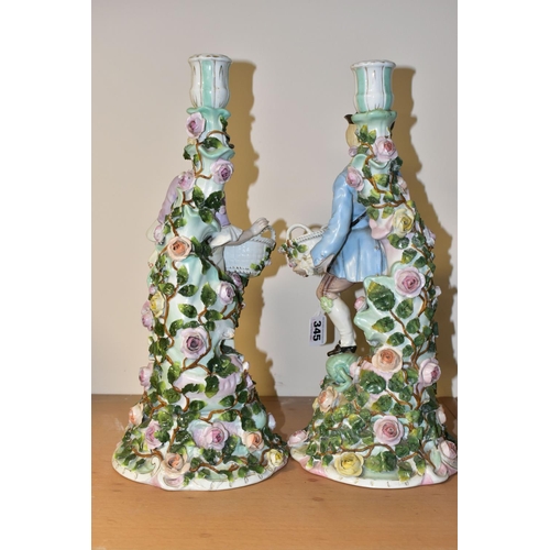 345 - A PAIR OF LATE 19TH CENTURY SITZENDORF FLORAL ENCRUSTED FIGURAL CANDLESTICKS, modelled as a male and... 