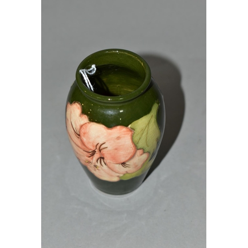 351 - A MOORCROFT POTTERY BALUSTER SHAPED BUD VASE DECORATED WITH CORAL HIBISCUS ON A GREEN GROUND, impres... 