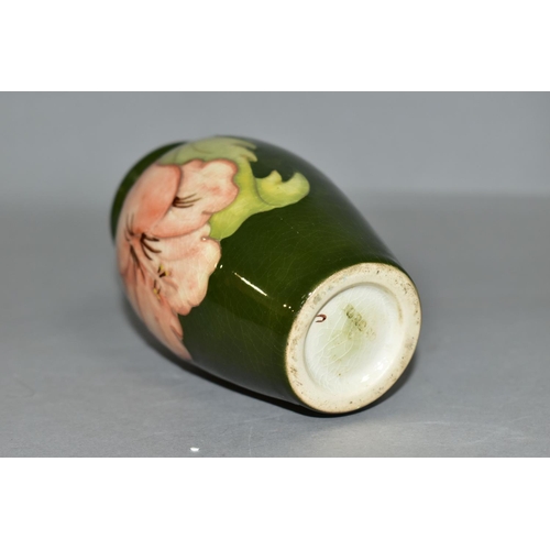 351 - A MOORCROFT POTTERY BALUSTER SHAPED BUD VASE DECORATED WITH CORAL HIBISCUS ON A GREEN GROUND, impres... 