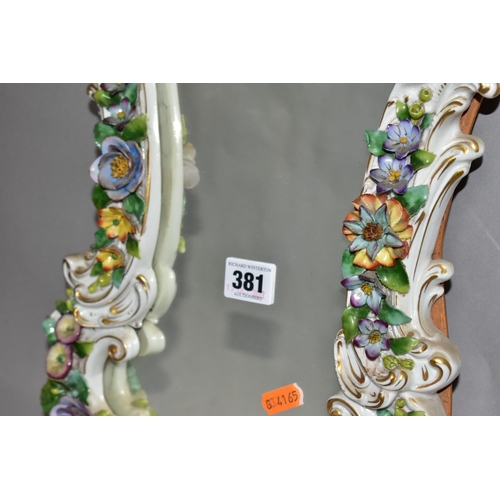 381 - A MID 20TH CENTURY CAPODIMONTE FLORAL ENCRUSTED PORCELAIN FRAMED MIRROR, Rococo style frame, the bac... 