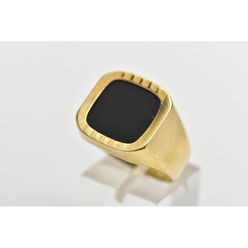 1 - AN ONYX SIGNET RING, the square shape onyx panel, within a part textured and polished surround, to t... 