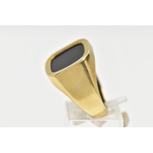 1 - AN ONYX SIGNET RING, the square shape onyx panel, within a part textured and polished surround, to t... 