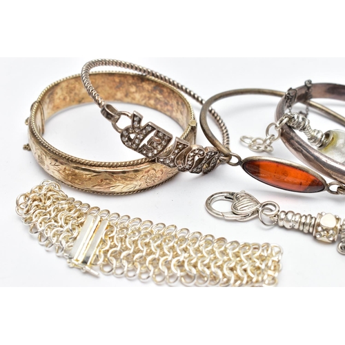 29 - TWO SILVER BANGLES AND ASSORTED WHITE METAL BRACELETS, the first a hinged bangle with floral engravi... 