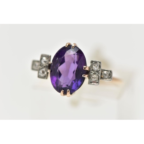 54 - AN EARLY 20TH CENTURY DRESS RING, an oval cut deep purple amethyst, prong set in yellow gold, flanke... 