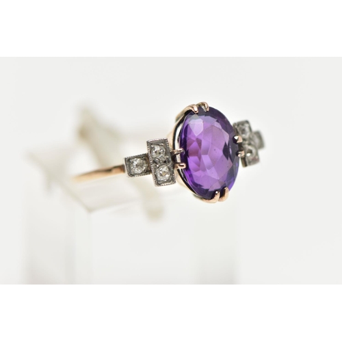 54 - AN EARLY 20TH CENTURY DRESS RING, an oval cut deep purple amethyst, prong set in yellow gold, flanke... 