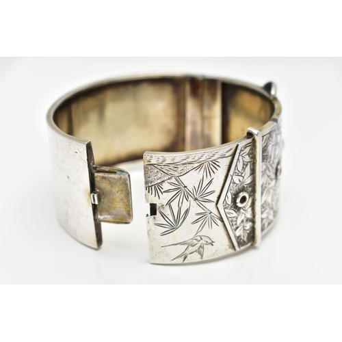 64 - A WHITE METAL HINGED BANGLE, wide bangle approximate width 30.3mm, in the form of a belt and buckle ... 