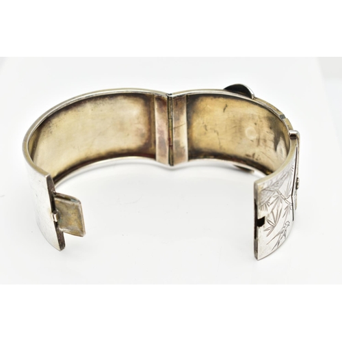 64 - A WHITE METAL HINGED BANGLE, wide bangle approximate width 30.3mm, in the form of a belt and buckle ... 