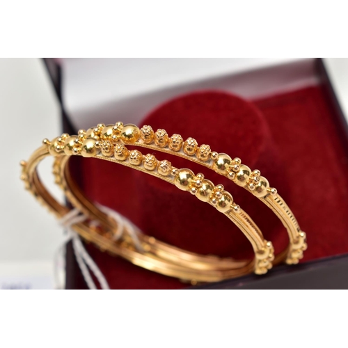 138 - TWO ASIAN GOLD BANGLES, each designed with spherical bead accents, engraved and rope twist detail, i... 