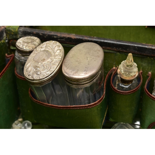 151 - A WORN TRAVEL VANITY CASE WITH VANITY PIECES, brown leather case with metal lock fittings, opens to ... 